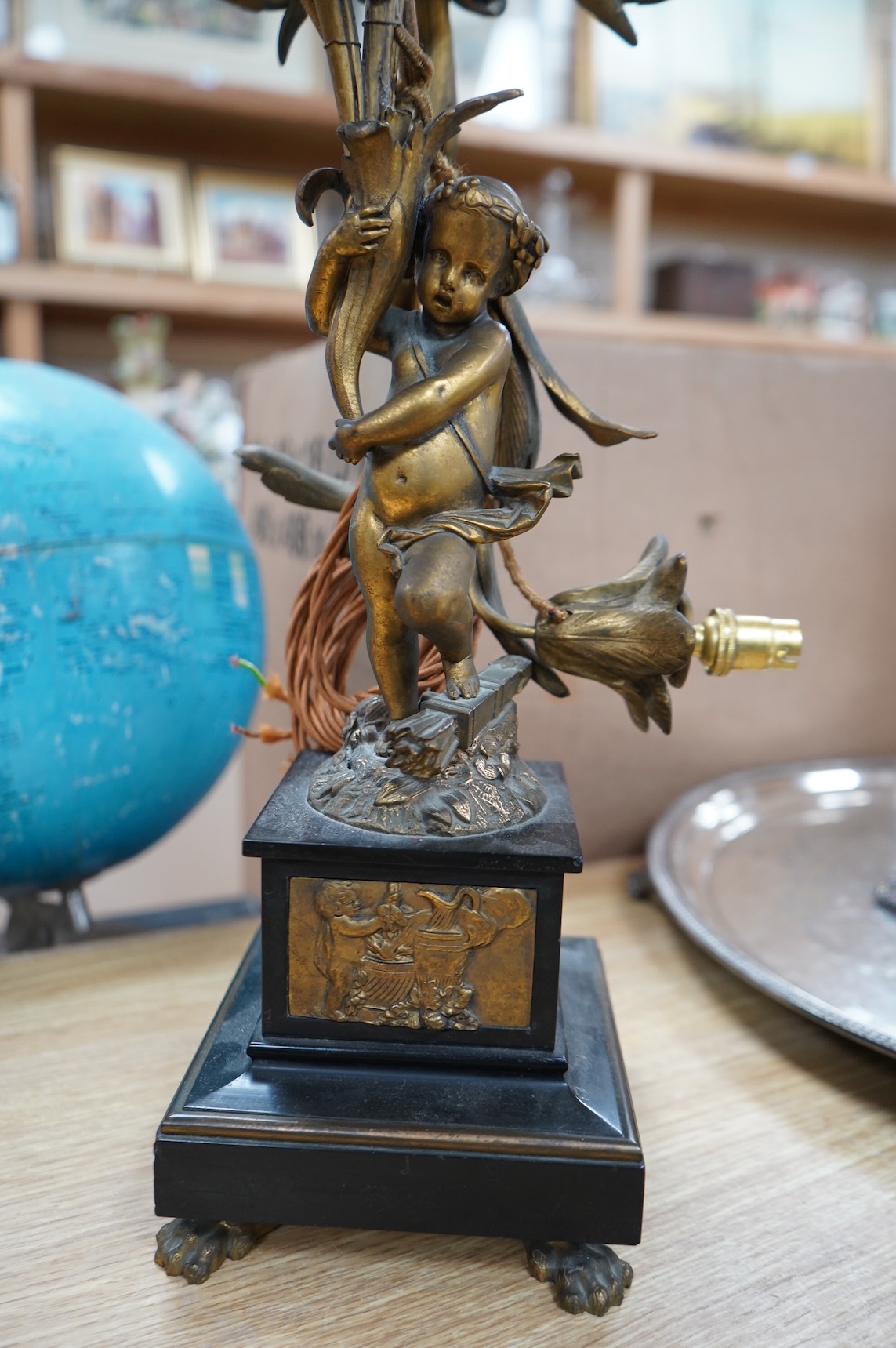An early 20th century ormolu and marble ‘cherub’ converted candelabra and a brass desk stand, tallest 56cm